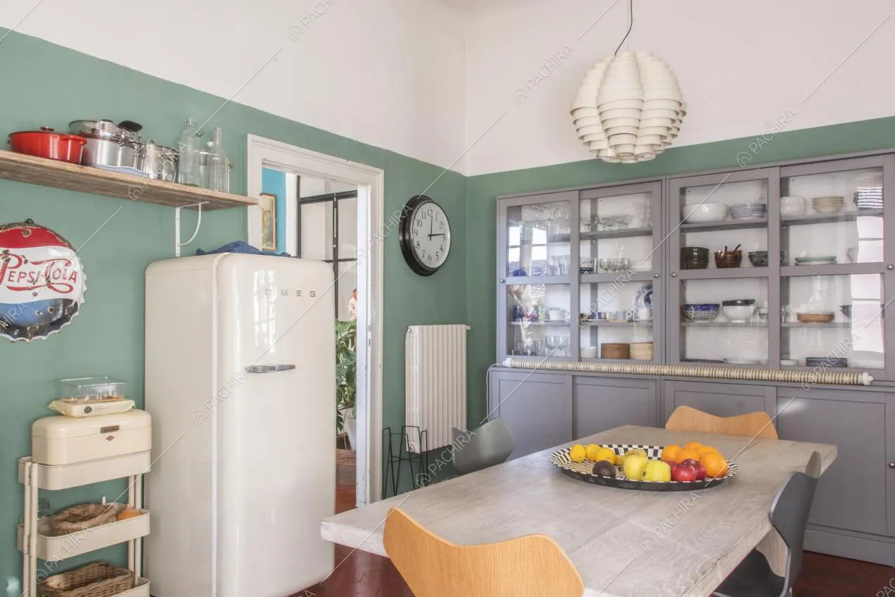 Frigorifero di design bianco, tavolo da pranzo e lampada a sospensione moderna