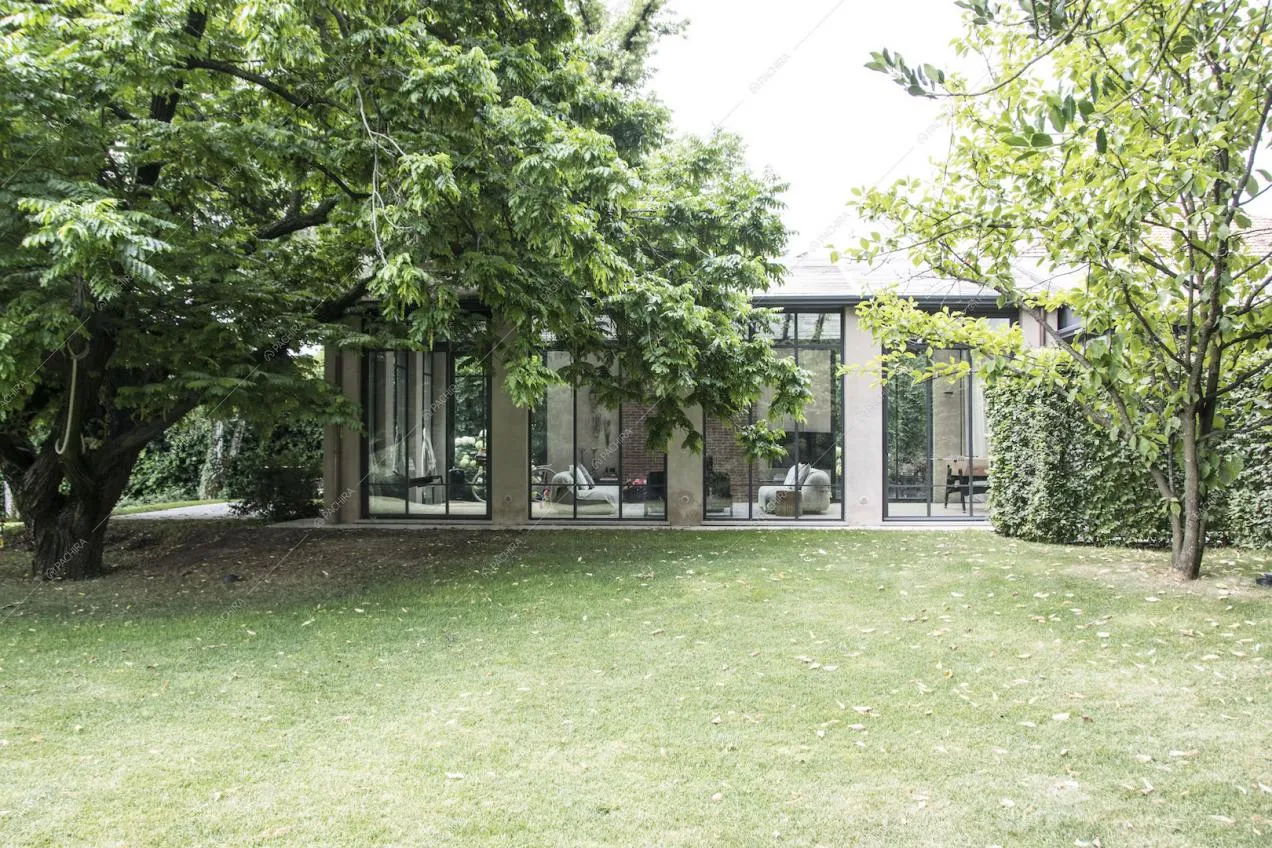 Gli interni della villa visti dal giardino attraverso le vetrate