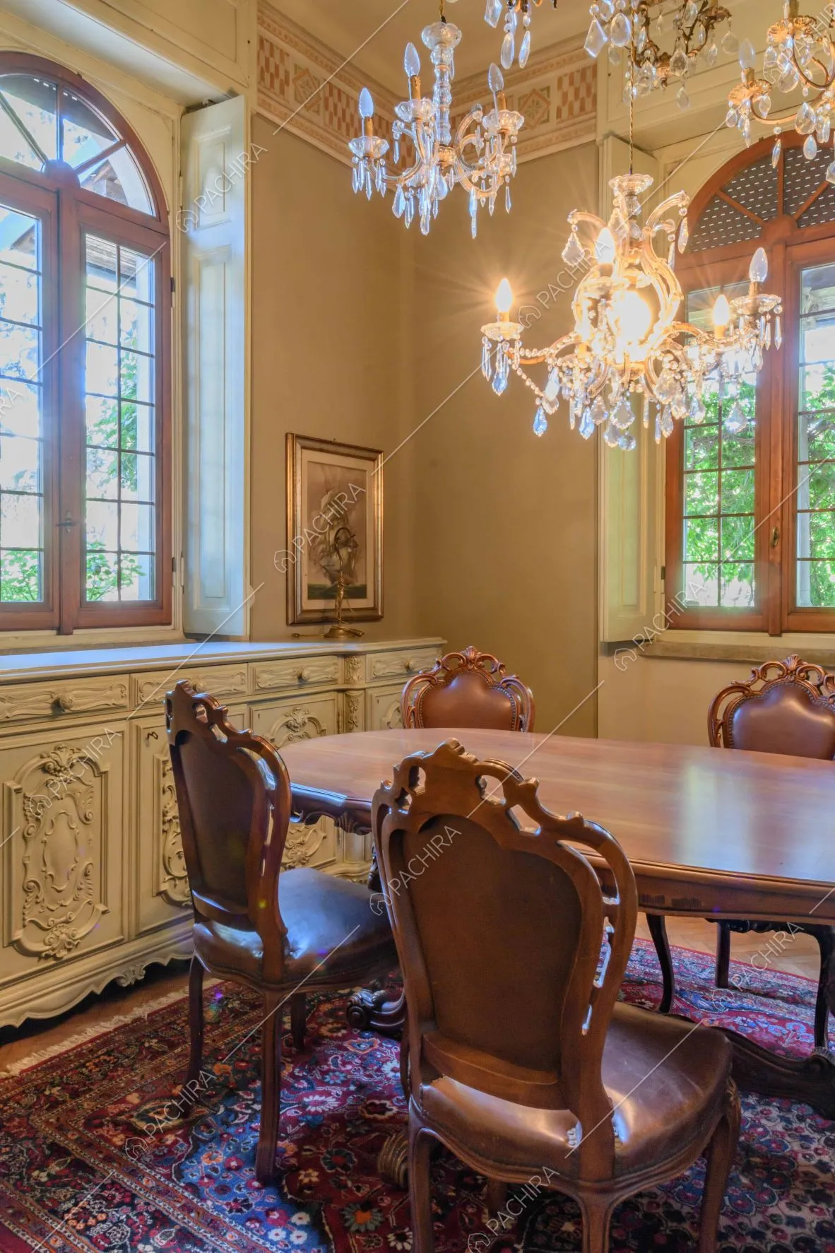 Sala da pranzo con lampadario di cristallo in stile barocco e vetrate