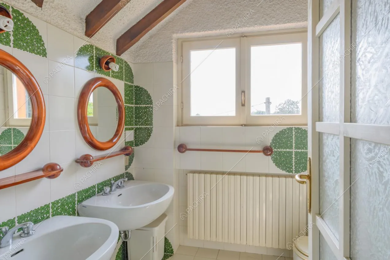 Bagno con piastrelle bianche e verdi sulle pareti