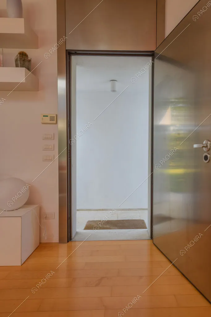 Ingresso della location con pavimento in parquet e parete bianca