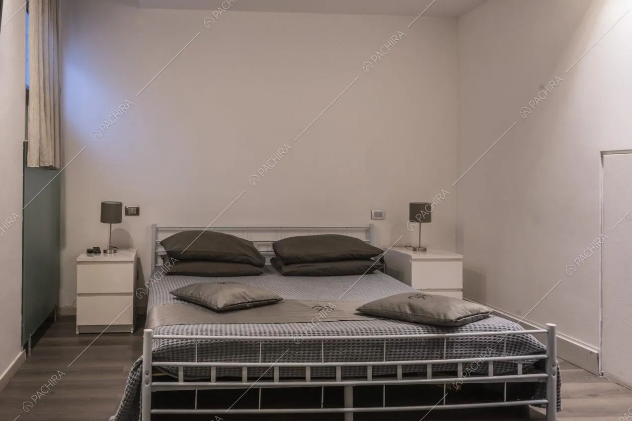 Letto matrimoniale con struttura in metallo e cuscini