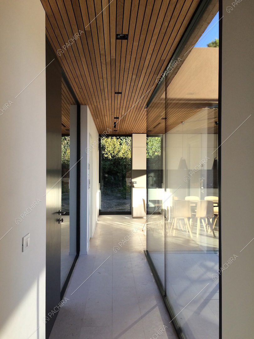 Corridoio con vetrate che si affacciano sulla veranda e scorcio sulla cucina a muro