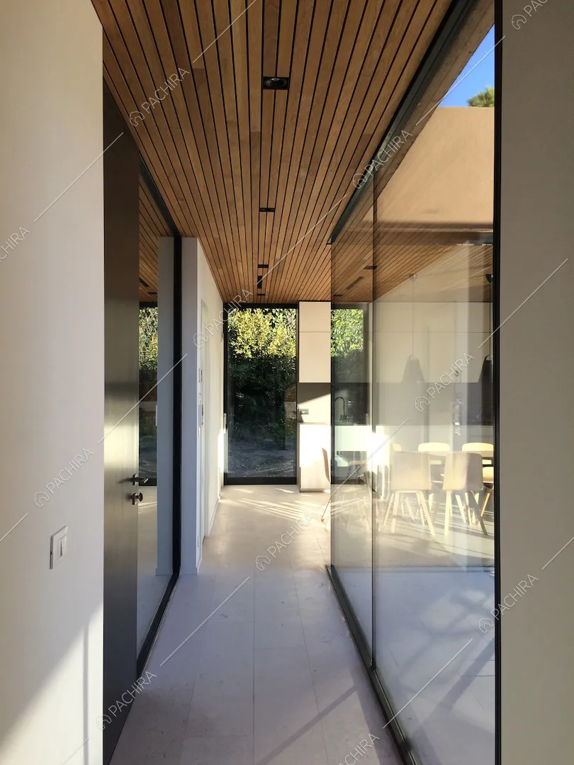 Corridoio con vetrate che si affacciano sulla veranda e scorcio sulla cucina a muro