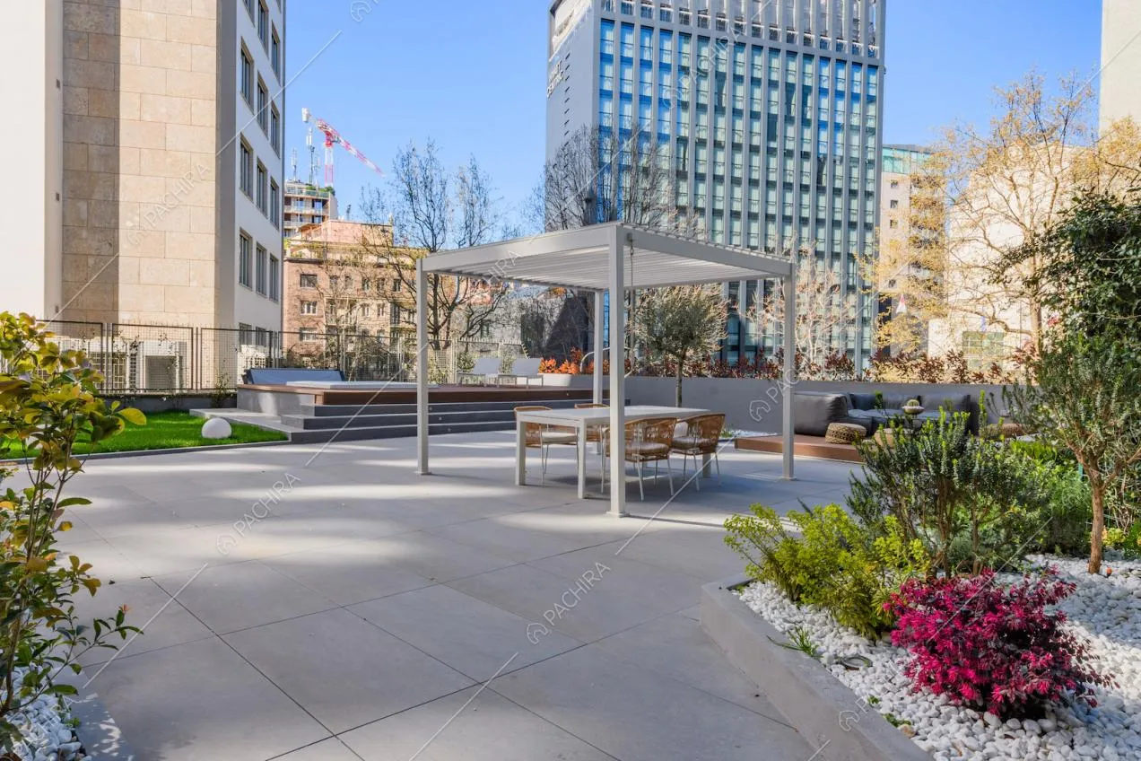 Sulla grande terrazza gazebo bianco e tavolo da pranzo