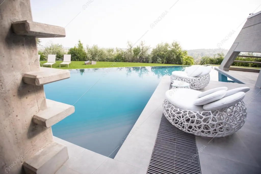 Poltrone da giardino bianche sul bordo della piscina