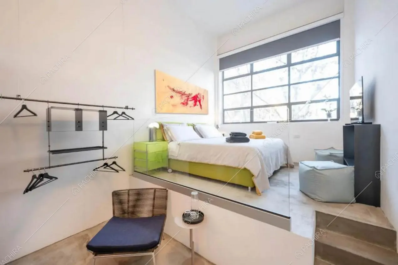 Camera da letto matrimoniale con finestra in stile industriale e pareti bianche