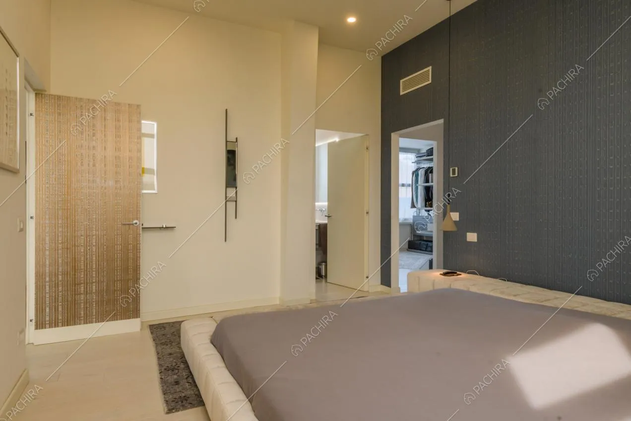 Camera da letto matrimoniale con parete blu, cabina armadio e bagno privato