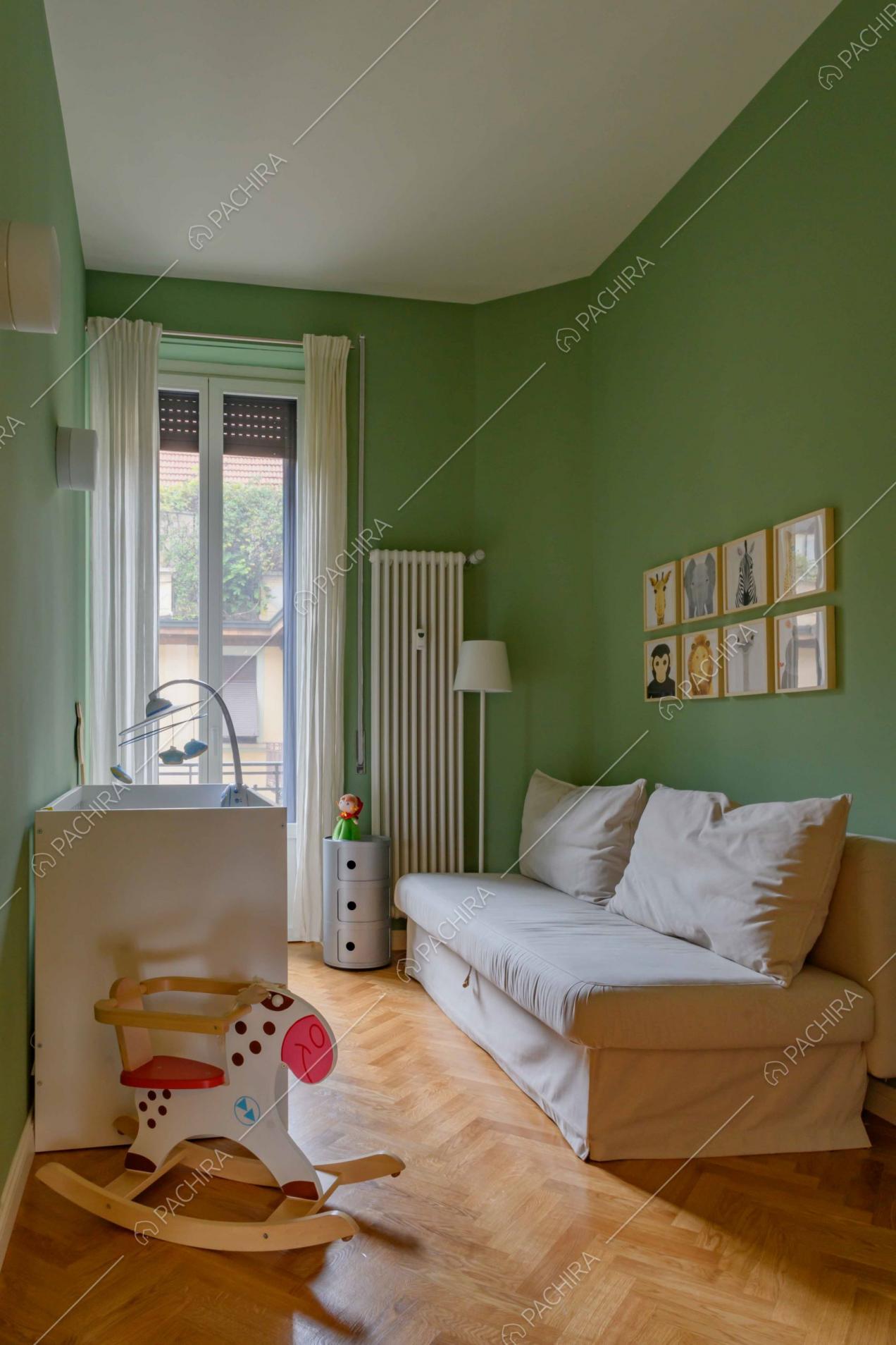 Camera da letto da bambini dalle pareti verdi e dal pavimento in parquet a spina di pesce