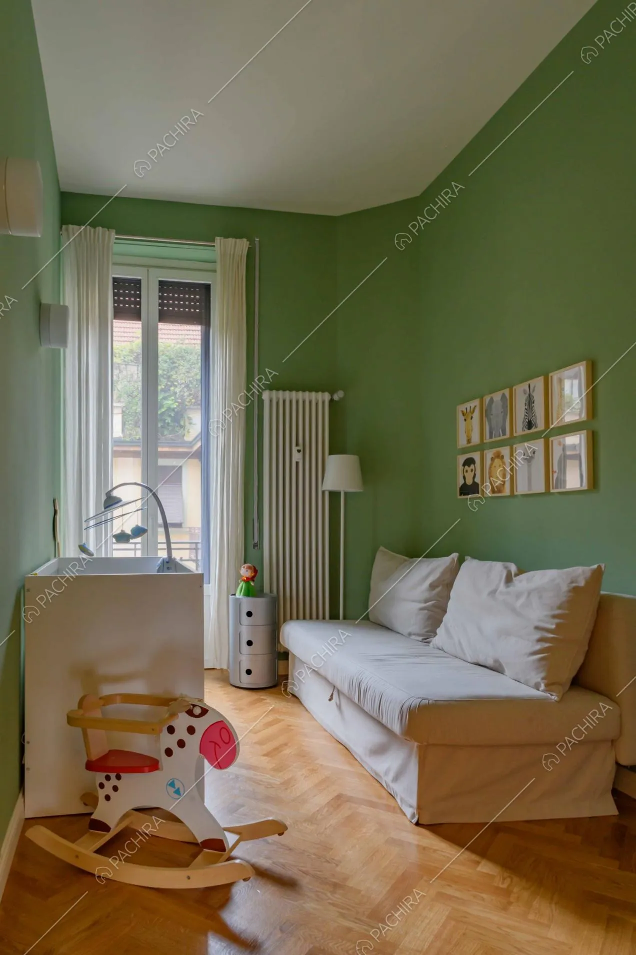 Camera da letto da bambini dalle pareti verdi e dal pavimento in parquet a spina di pesce