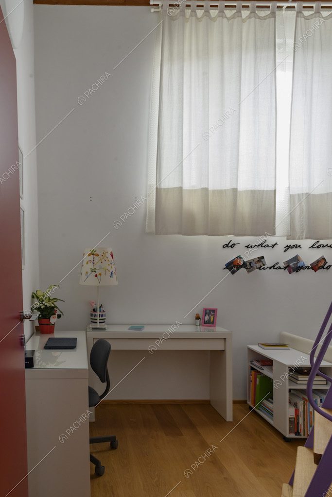 Camera da letto dalla porta rossa con scrivania bianca e pavimento in parquet