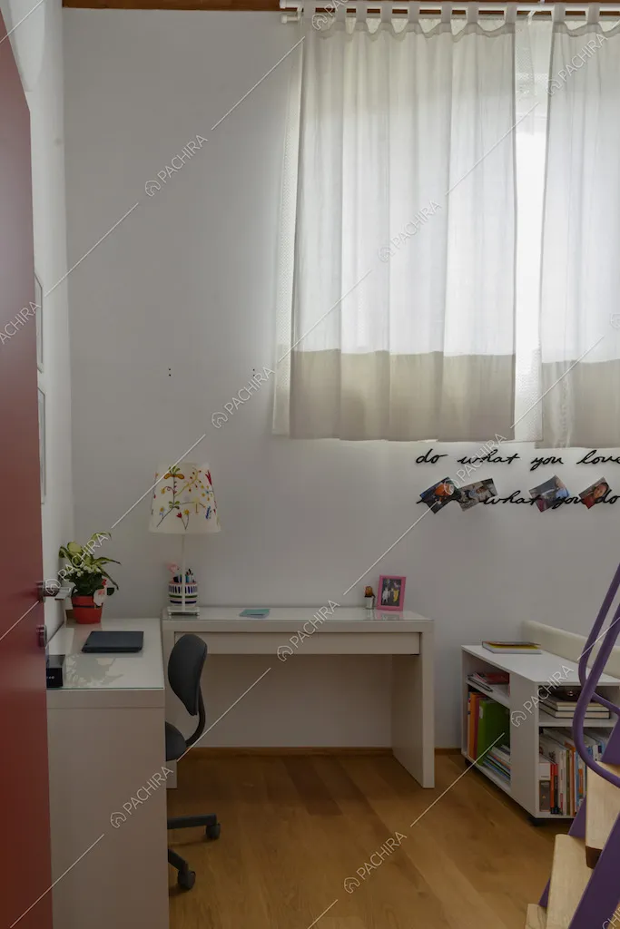 Camera da letto dalla porta rossa con scrivania bianca e pavimento in parquet
