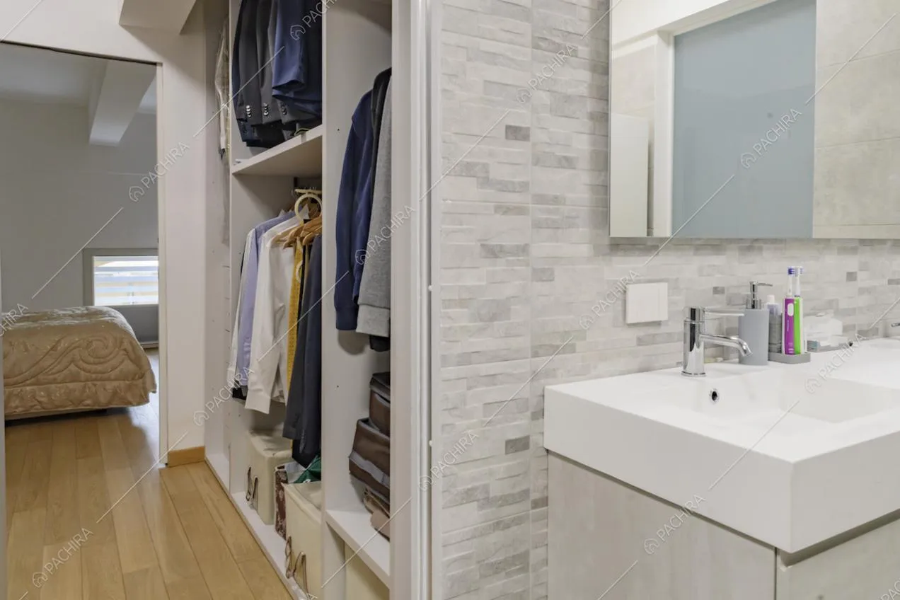 Bagno privato della camera da letto con cabina armadio e pavimento in parquet