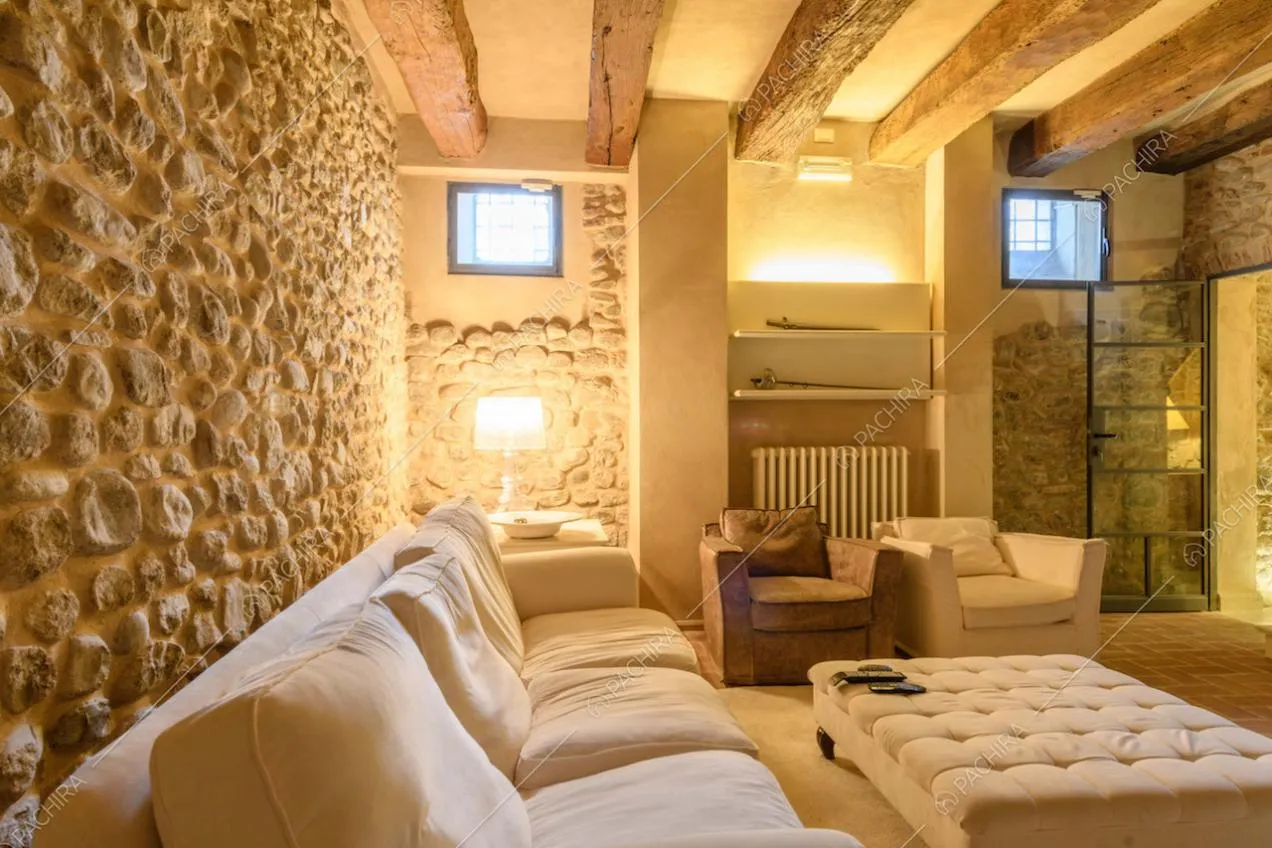 Pareti in pietra nella taverna con divano, pouf e poltrone