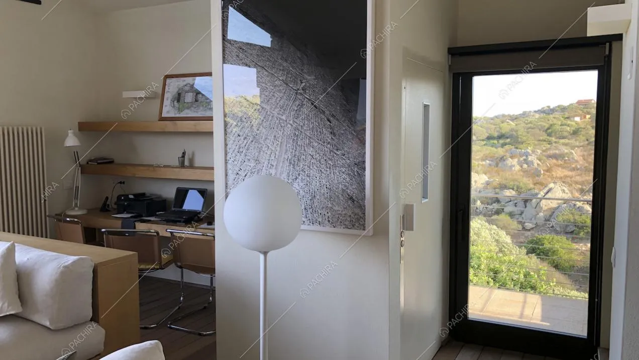 Angolo studio con mensole in legno, quadro astratto e lampada da terra