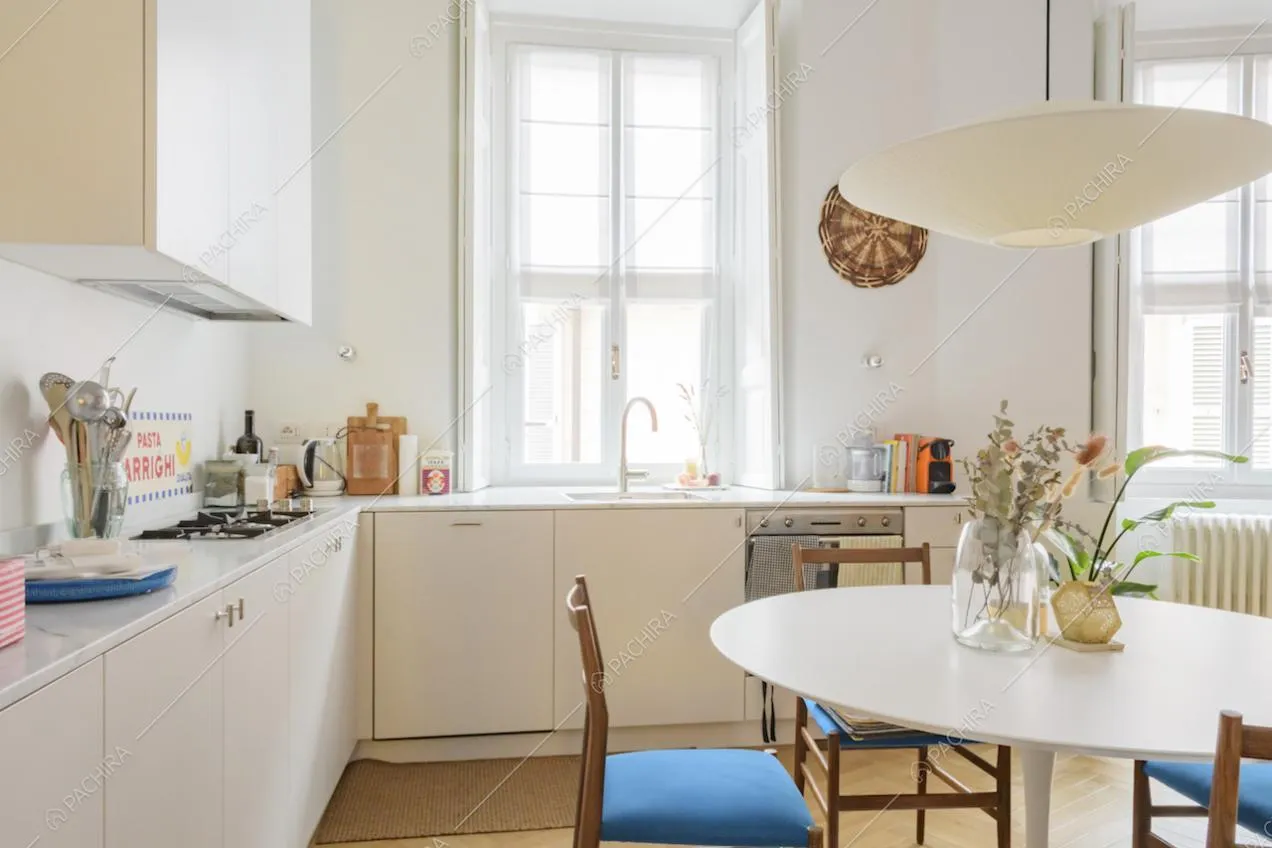 Cucina bianca a muro con fornelli a gas e lampadario di design