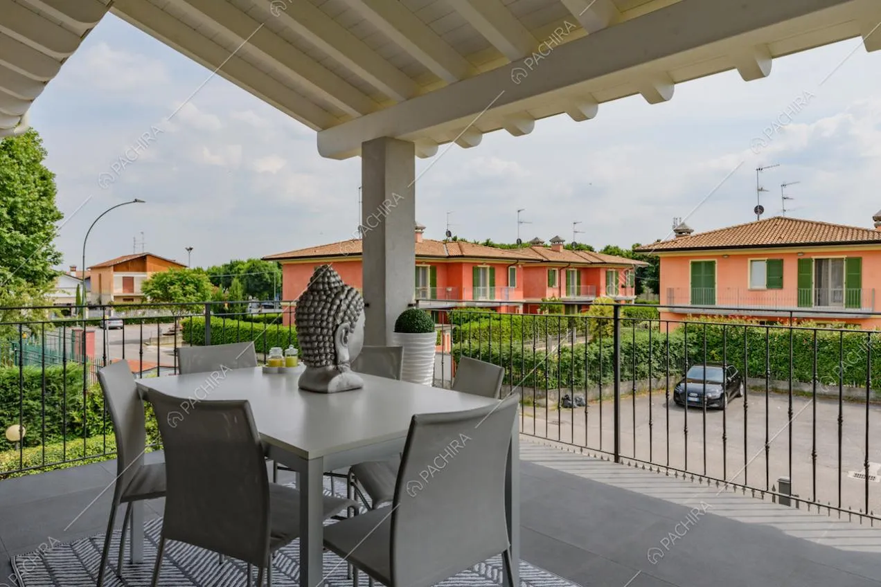 Terrazza con tavolo da pranzo e travi bianche in legno a vista