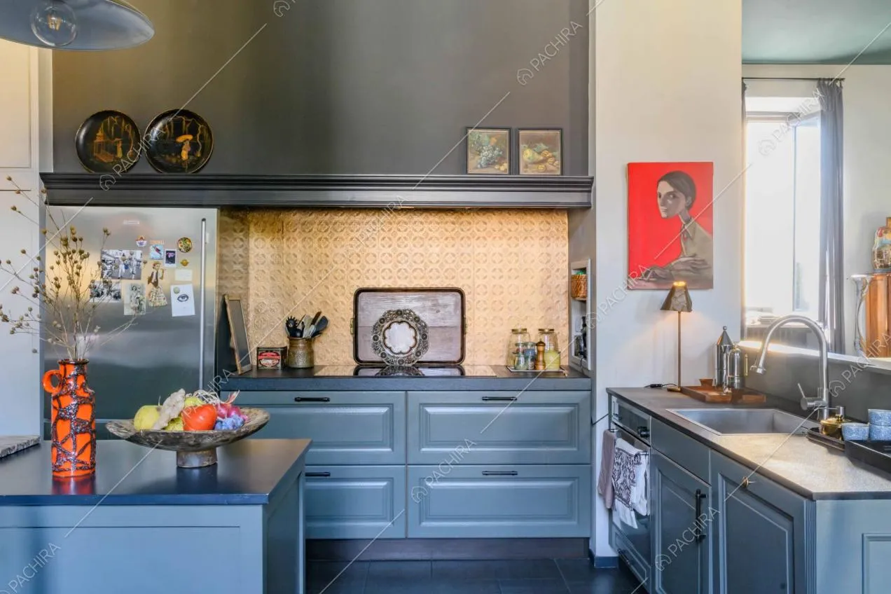 Cucina con paraschizzi color oro, fornelli a induzione e pavimento nero in gres