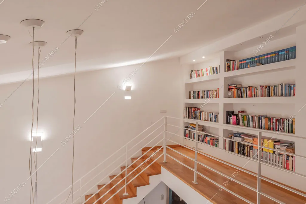 Libreria sul soppalco con ringhiera bianca della villa Bauxite, location in stile moderno a Roma
