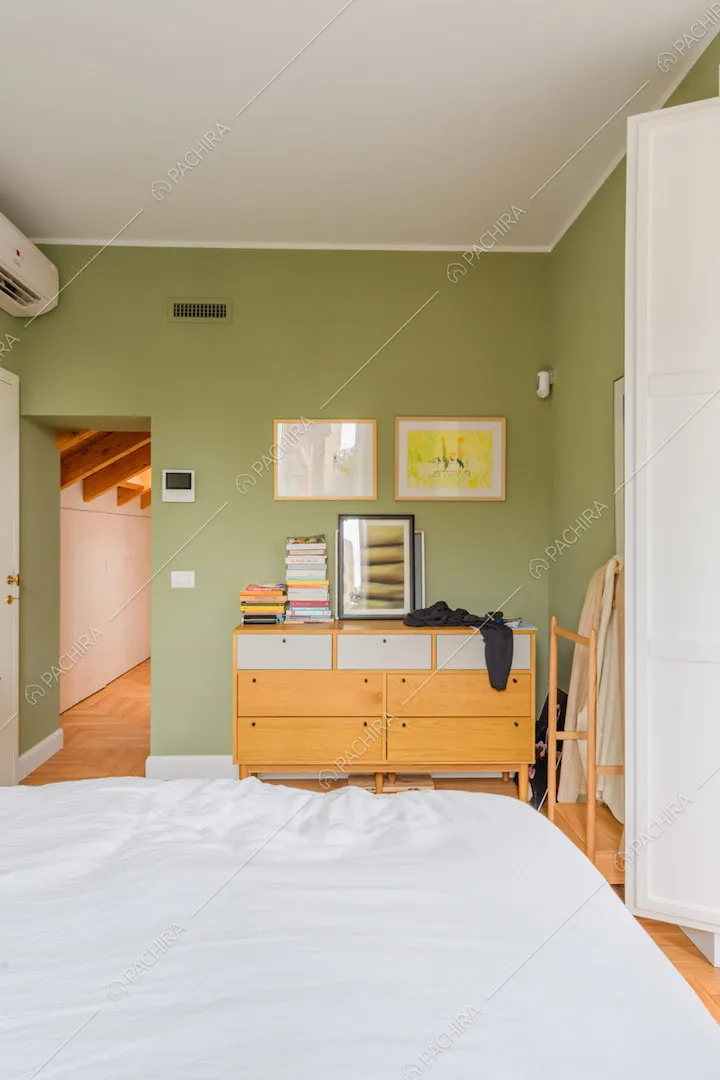 Camera da letto matrimoniale con pareti verdi e pavimento in parquet