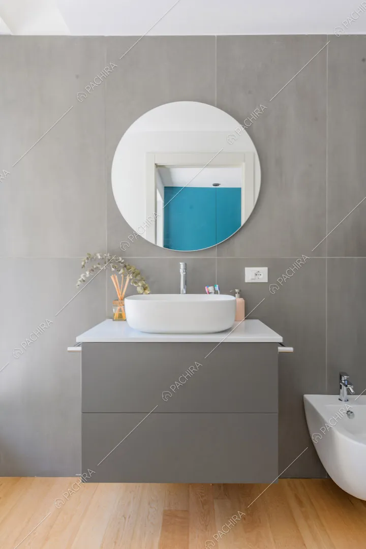 Bagno con mobile sospeso, parete grigia e pavimento in parquet