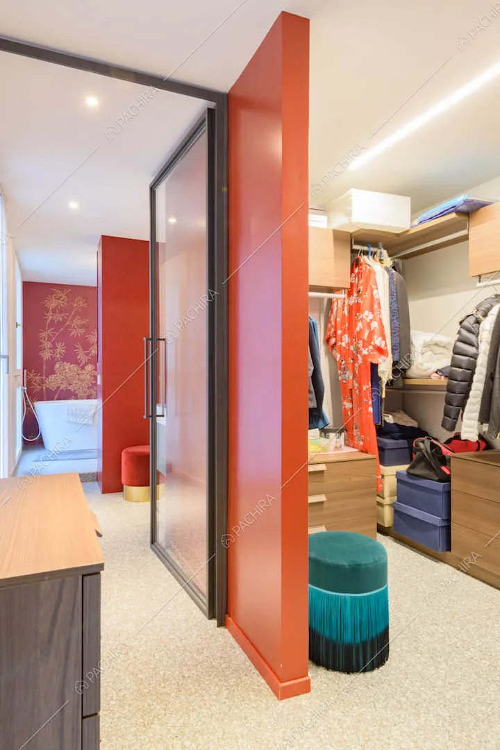 Cabina armadio della camera da letto matrimoniale e scorcio sul bagno dalle pareti rosse