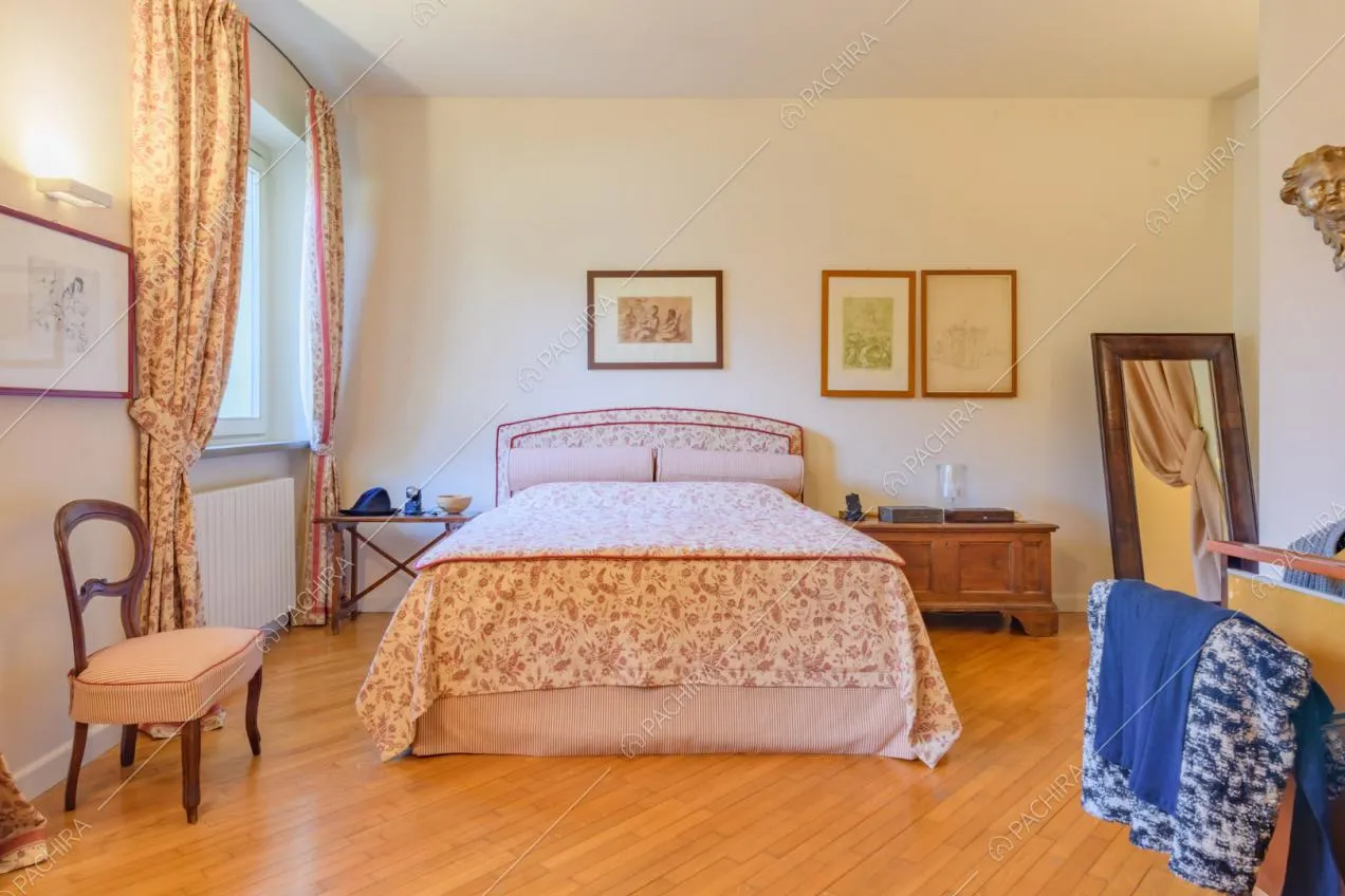 Camera da letto matrimoniale con pareti bianche e pavimento in parquet