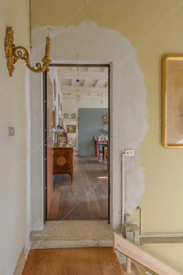 Dall'atrio vista sulla zona living con soffitto bianco a cassettoni e pavimento in parquet