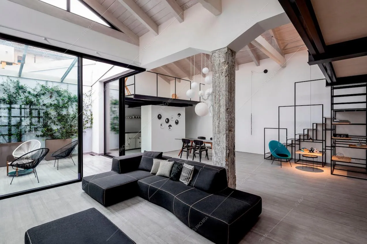 Divano nero con isola, giardino d'inverno e cucina parzialmente a vista