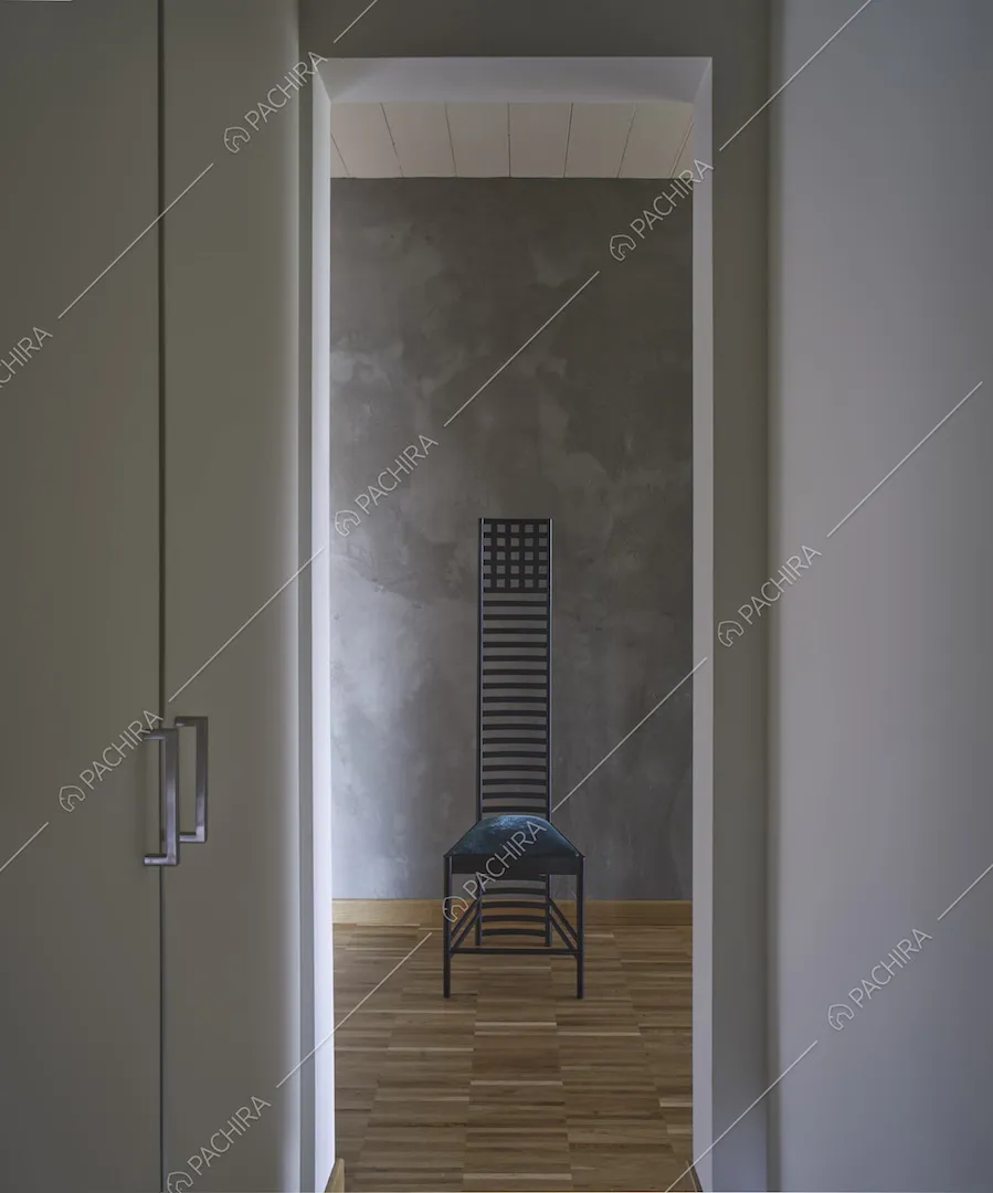 Dal corridoio con pavimento in parquet vista su sedia nera di design