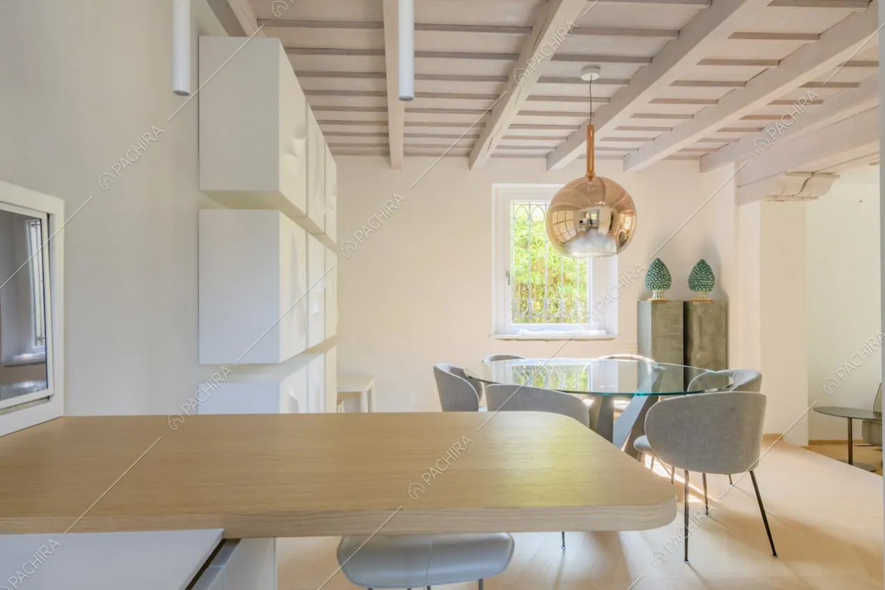 Penisola in legno della cucina e vista sul tavolo da pranzo del salotto