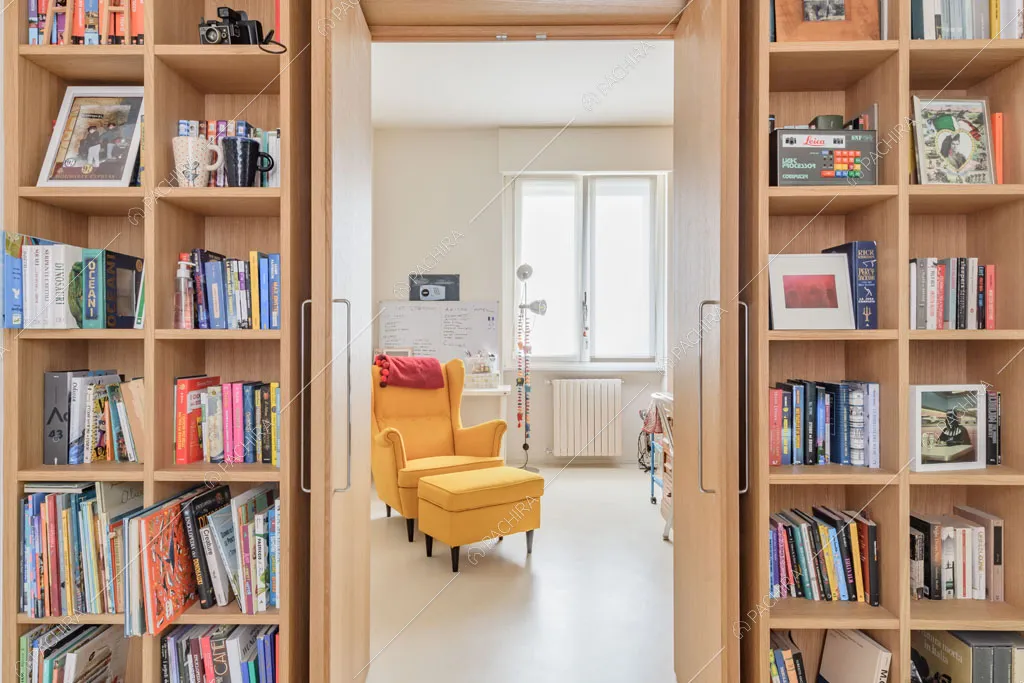 Libreria a parete dell'appartamento Papagayo, location in stile contemporaneo a Milano