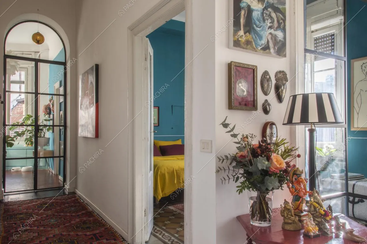 Lampada a righe bianche e nere, vaso con fiori e soprammobili