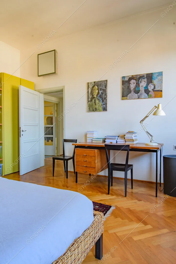 Scrivania in legno e metallo nella camera da letto matrimoniale con pavimento in parquet