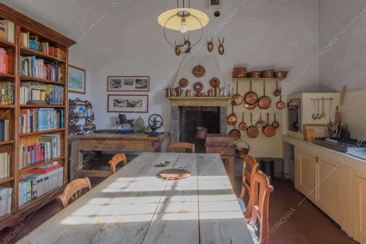 Tavolo da pranzo in legno nella cucina a parete con fornelli a gas e camino
