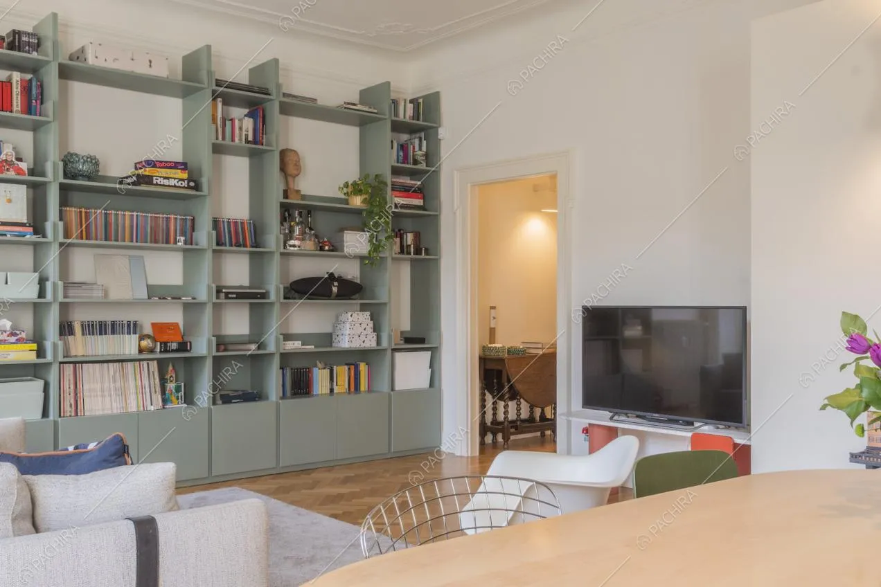 Libreria a parete con libri e soprammobili in salotto