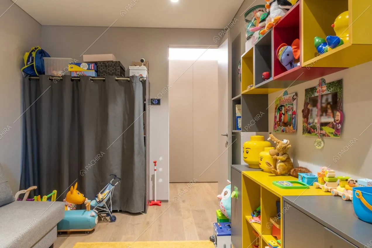 Dalla sala giochi con libreria colorata vista sul corridoio con armadi a parete