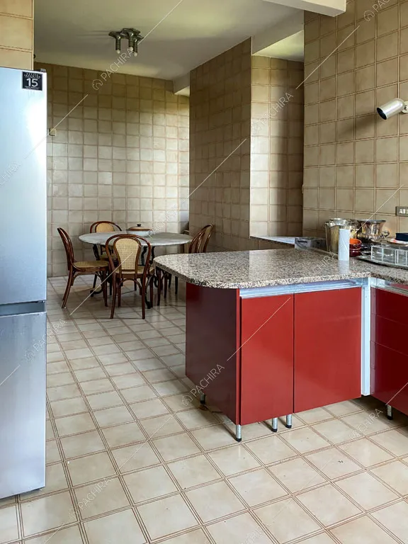 Cucina rossa con piastrelle beige su pavimento e pareti