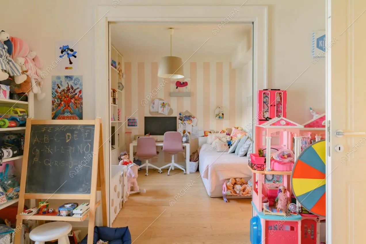 Camera da letto dei bambini con parete a strisce bianche e rosa