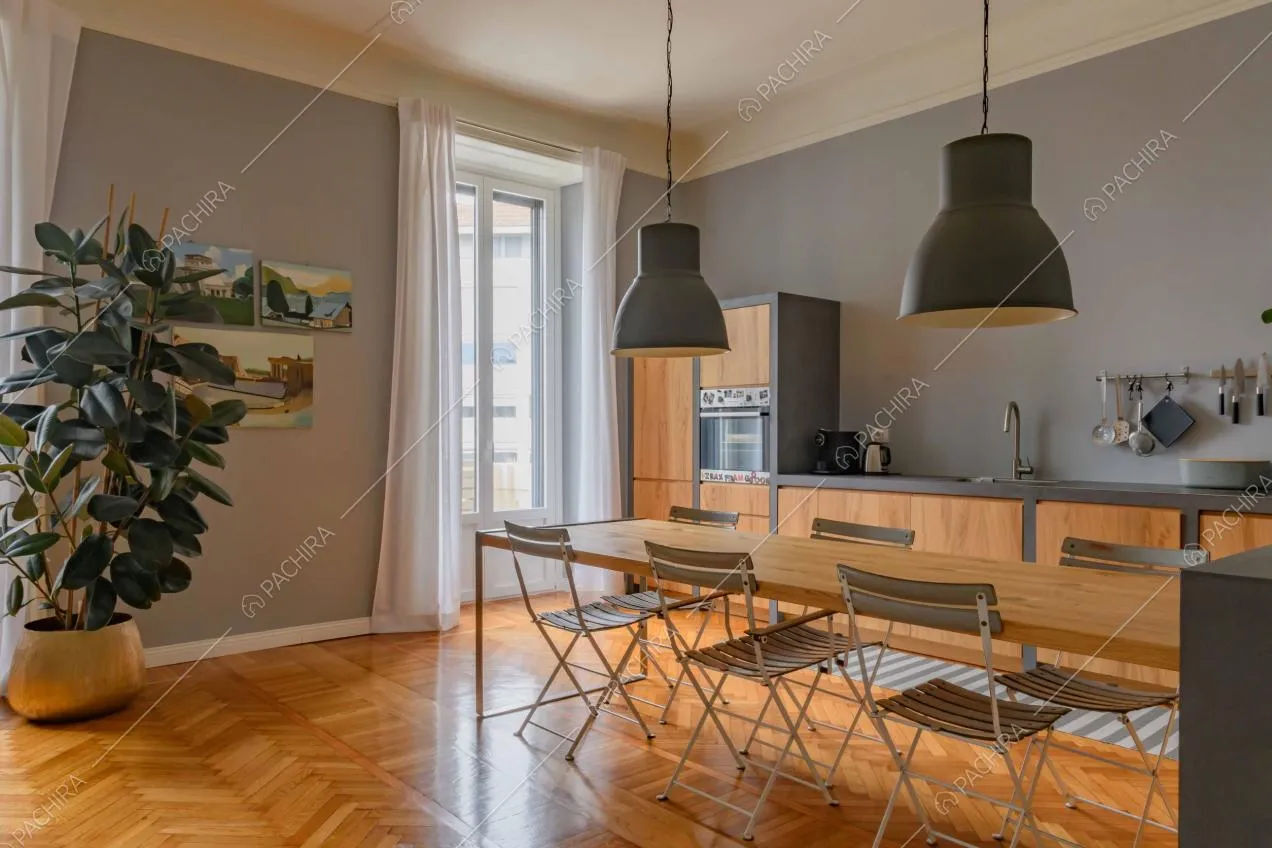 Pavimento in parquet a spina di pesce e pareti grigie nella luminosa cucina a parete