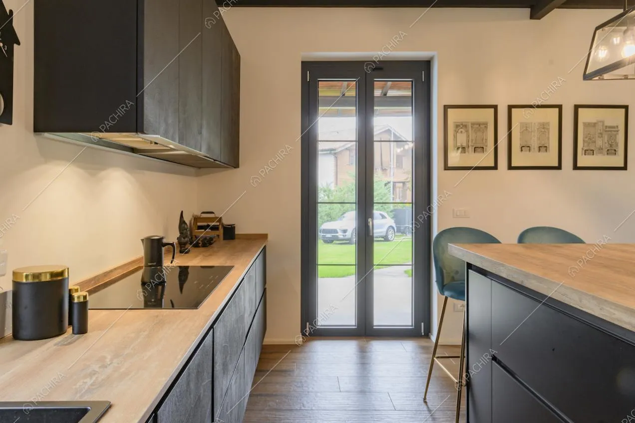 Cucina con piano di lavoro in legno e porta finestra