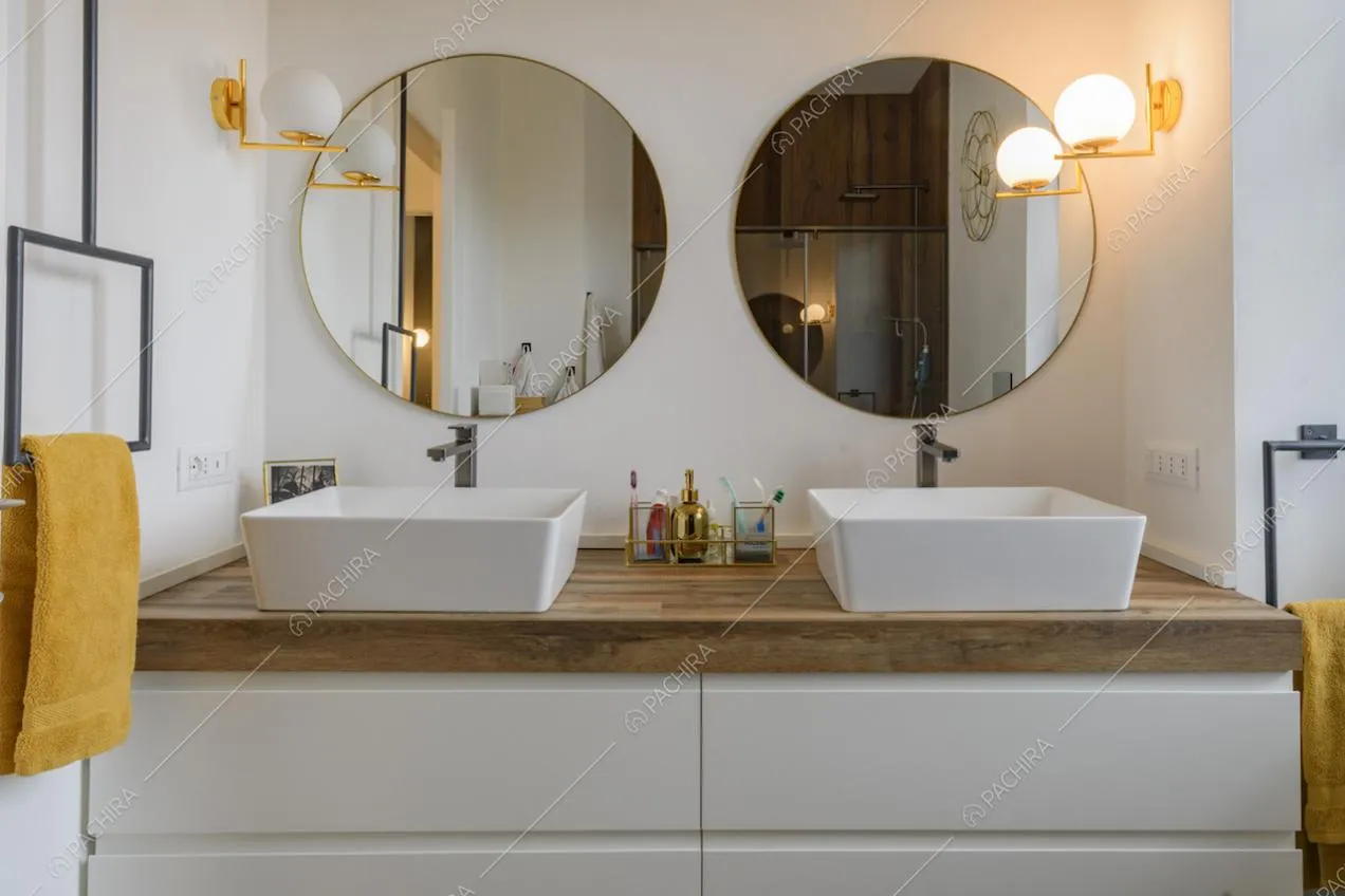 Specchi tondi e applique sopra ai lavandini moderni del bagno