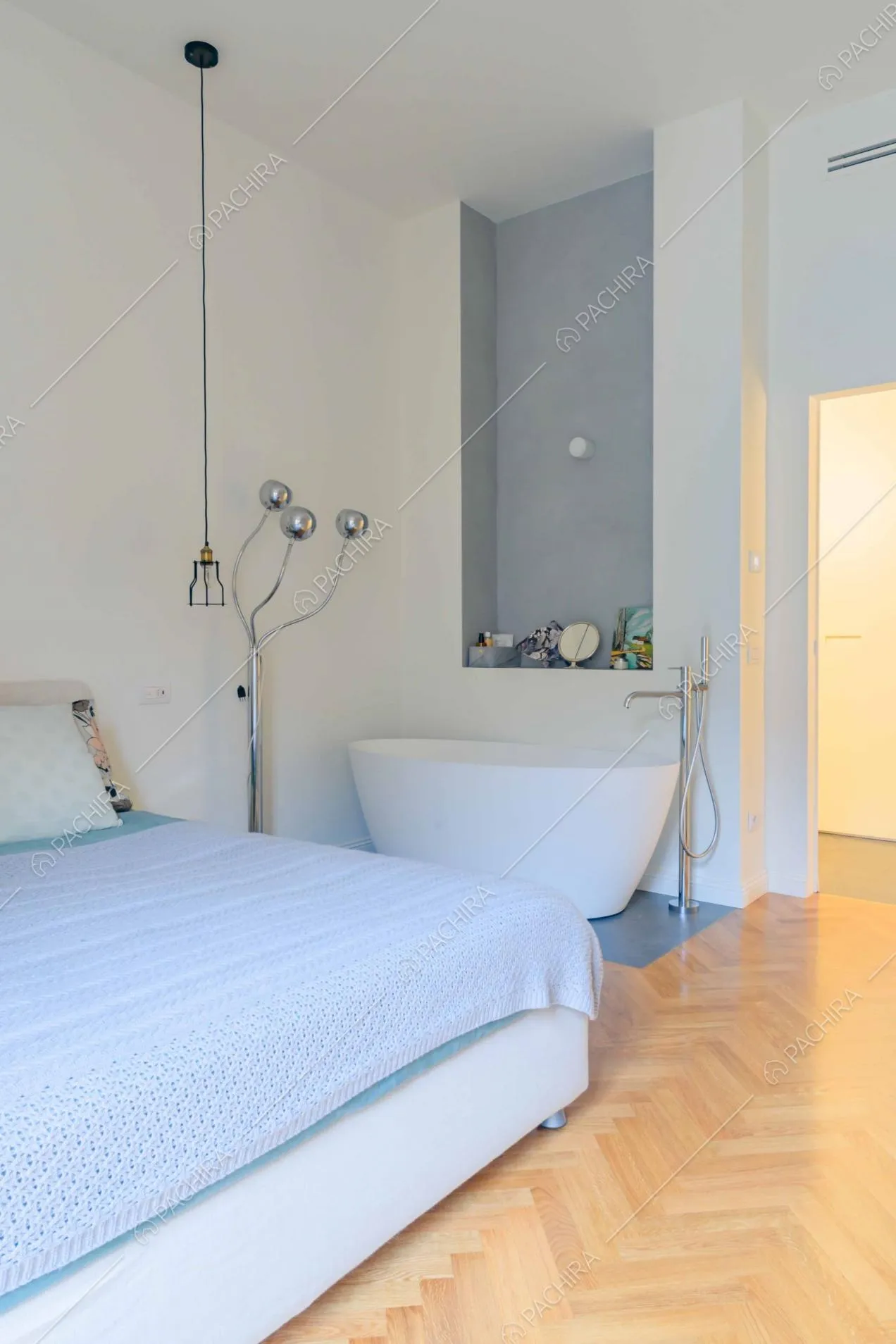 Camera da letto matrimoniale con vasca da bagno e pareti bianche