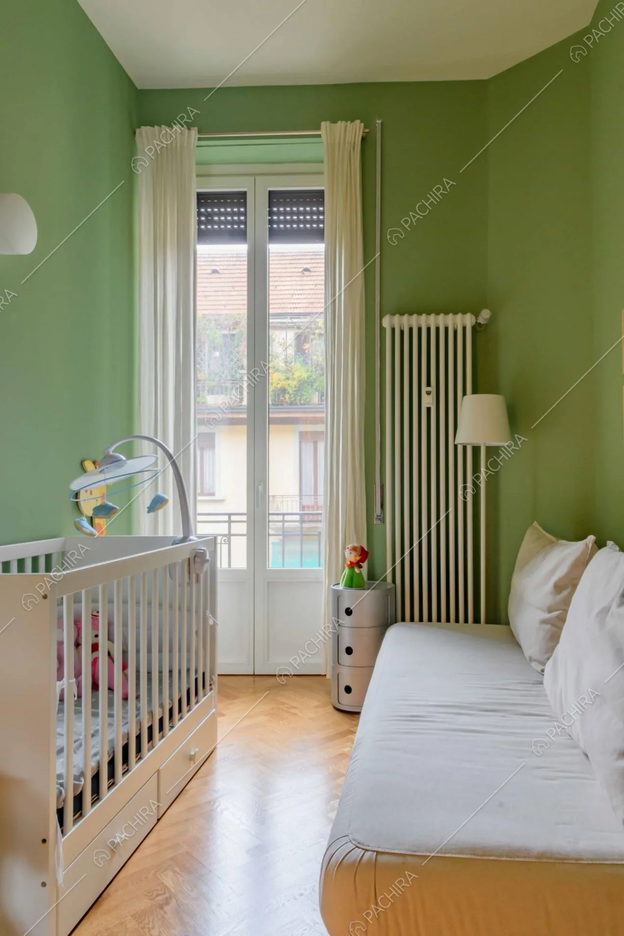 Pavimento in parquet a spina di pesce e pareti verdi nella camera da bambini