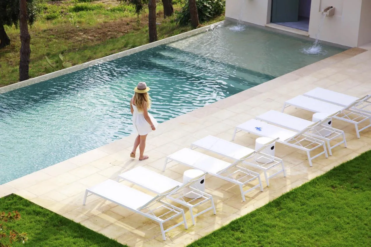 Vista sulla piscina e sui lettini bianchi nel giardino