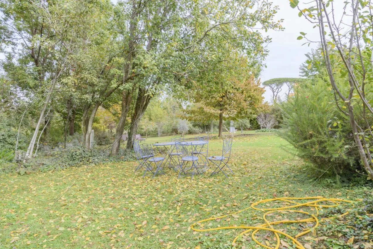 Parco intorno alla Location Nerina e tavolino con sedie in ferro