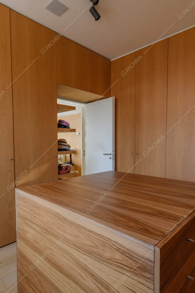 Cabina armadio con pareti in legno, pavimento in parquet e cassettiera