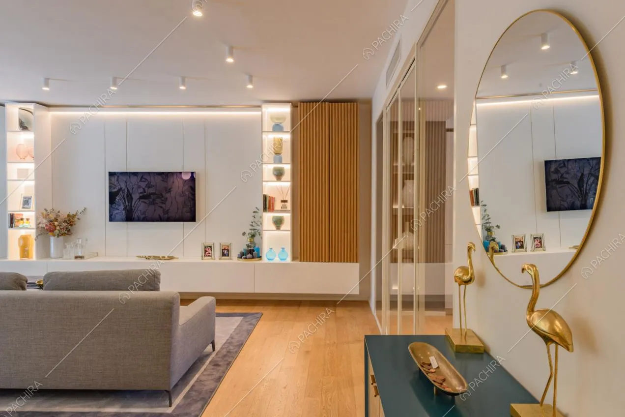 Pavimento in parquet nella zona living con pareti bianche e divano grigio