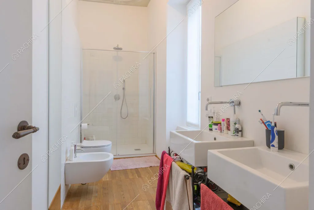 Grande bagno con box-doccia, sanitari sospesi e doppio lavandino