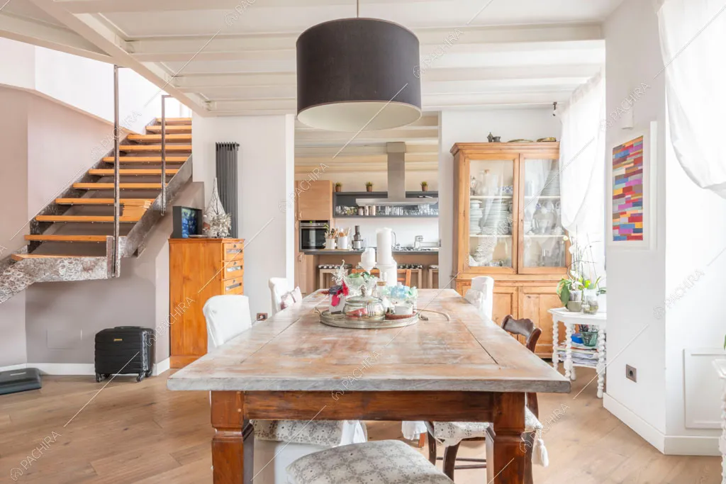 Sala con travi a vista sul soffitto dell'appartamento Uru, location in stile moderno a Roma
